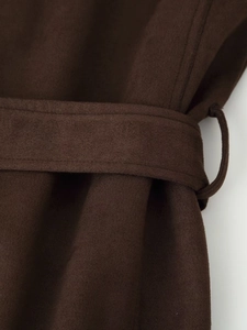 Close-up of the deep brown faux suede jacket fabric with belt loop and stitching detail