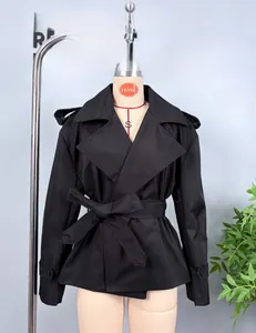 Detail of black cropped trench jacket featuring waist belt and classic epaulettes