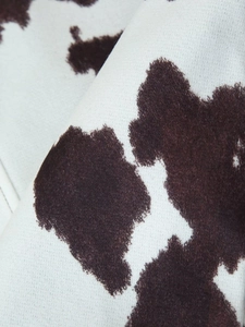 Makroansicht der weichen Textur und des Kuhmusters auf dem Stoff der Jacke im Detail