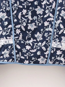Detail view of the quilted floral pattern and side pocket on the reversible cotton jacket
