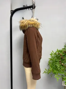 Detail view of the dense faux fur collar and ribbed cuffs on a brown short jacket