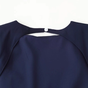 Dark blue dress back view with teardrop cutout and white button closure detail