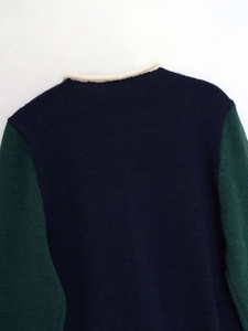 Detail of color-block knit sweater with navy body, green sleeves and white rib collar