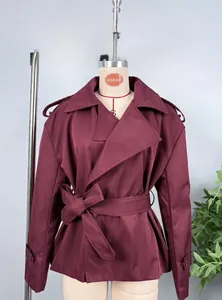 Detail of burgundy cropped trench jacket featuring lapels and belted waist closure