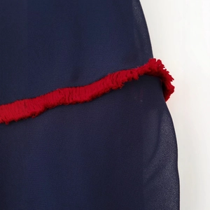 Color block contrast dress featuring deep blue chiffon with vibrant red fringe trim