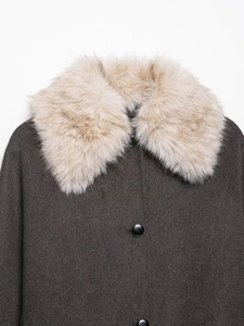 Detailed close-up of wool coat with wide collar and plush faux fox fur trim