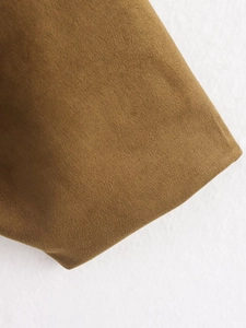 Macro shot of brown faux-suede fabric texture and clean edge stitching on the jacket