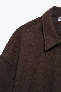 Macro shot of dark brown wool jacket collar with detailed texture and interior label