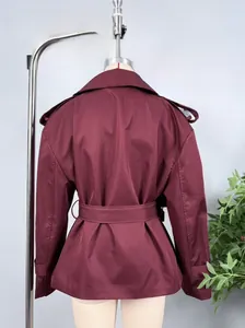 Detail view of burgundy cropped windbreaker jacket with back storm flap and belt details