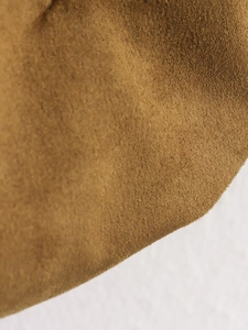 Macro shot of premium tan brown suede fabric with a soft textured finish on the jacket