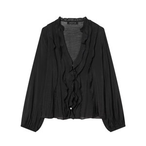 Detail van gelaagde ruches op een zwarte semitransparante blouse met diepe V-halslijn