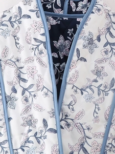 Macro shot of diamond quilting and floral patterns on reversible sleeveless vest