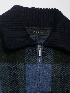 Dettaglio del cardigan in maglia a scacchi blu e verde con cerniera in metallo argento