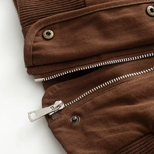 Detail of dark brown jacket with metal zipper and vintage star-embossed snap buttons