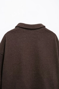 Detail view of the collar and drop shoulder of a dark brown wool blend jacket