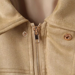 Détail d'un blouson aviateur en daim camel avec fermeture éclair dorée et bouton-pression