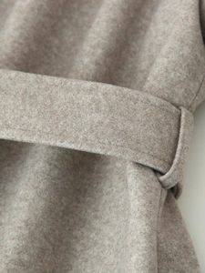 Detail of soft wool blend coat showing high-quality waist belt and stitching craftsmanship