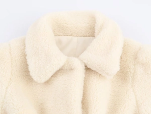 Close-up of the soft cream faux fur collar and smooth lining of the belted coat