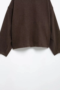 Detail view of smooth texture and stitching on dark brown wool blend jacket for women