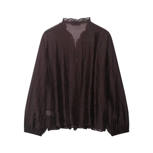 Detail of tan V-neck ruffled collar blouse with light chiffon fabric and long sleeves