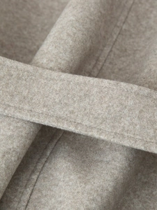 Detail of oat-beige wool coat featuring high-quality belt stitching and soft fabric texture