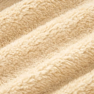 Macro shot of high-quality cream sherpa fleece fabric showing warm curly texture