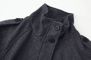 Détail d'une veste en laine gris foncé avec col montant, épaulettes et boutons