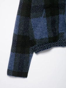 Macro del cardigan in maglia a quadri blu e neri con morbida trama effetto mohair