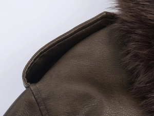 Detailed close-up of dark brown faux suede jacket with plush faux fur trim and fine stitching