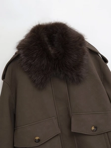 Close-up of vintage brown faux leather jacket featuring a plush faux fur collar and flap pockets