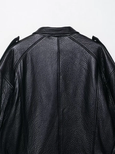 Détail de la texture cuir noir grainé sur le dos et l'épaule du blouson aviateur