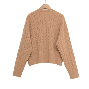 Detail of cable knit pattern and ribbed hem on camel brown crewneck sweater