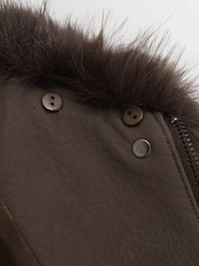 Close-up of dark brown faux leather jacket with plush fur collar and metallic snap buttons