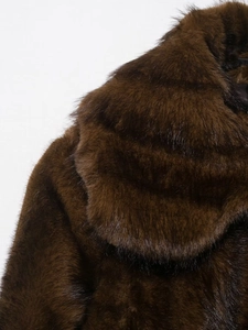 Detail of dark brown faux fur jacket showing thick, silky texture on collar and shoulder