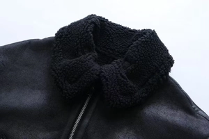 Close-up of black fleece collar and metal zipper on warm winter jacket with suede texture