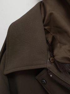 Detail view of smooth metal zipper and detachable faux fur collar on brown leather jacket