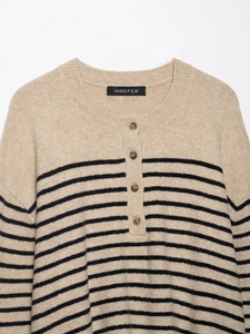 Detail of striped knit sweater with round neck, buttoned placket and soft fabric texture