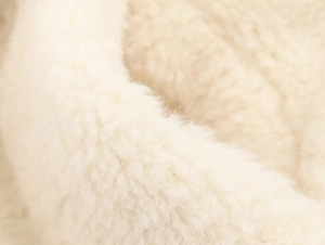 Close-up macro detail of soft cream faux fur texture on elegant winter coat