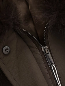 Detail of dark brown leather jacket with fluffy fur collar and silver metal zipper