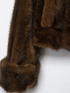 Close-up detail of soft dark brown faux fur texture on sleeve and jacket body