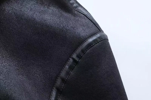 Detail of matte black sherpa jacket showing faux leather trim and neat seam stitching