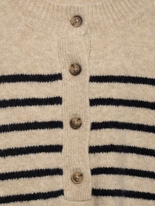 Macro detail of amber buttons and striped wool blend knit texture on a beige cardigan