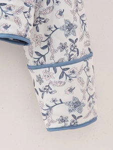 Detail of floral quilted jacket sleeve with blue piping and diamond texture