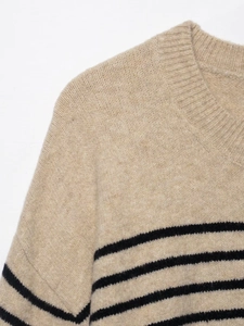 Detail view of the ribbed crew neck and soft knitted fabric texture of the striped sweater