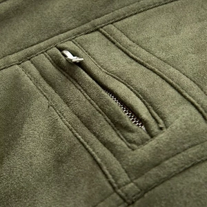 Vista macro de chaqueta de ante verde oliva con cremallera metálica y costuras decorativas
