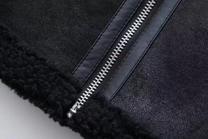 Detail of silver metal zipper with faux leather trim and black sherpa fleece lining on jacket