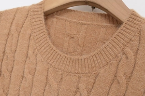 Detailed view of camel cable knit sweater featuring a ribbed crew neck and soft wool texture