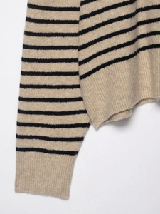 Detail of classic black and beige striped knit sweater with ribbed cuffs and soft wool texture
