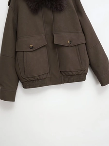 Detail view of brown faux fur collar and textured suede jacket with large utility pockets