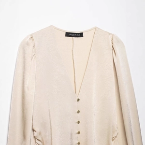 Champagne satin long sleeve blouse with deep V-neck and gold buttons on a white background